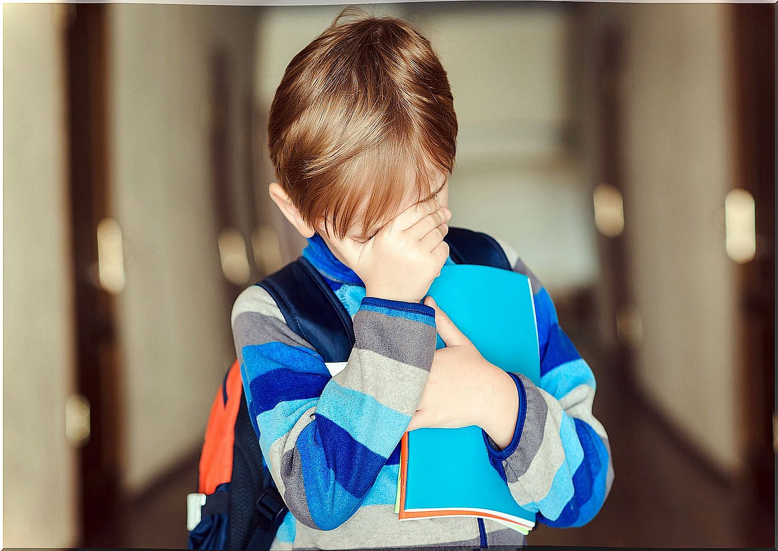 Child covering his face because they make him bully.