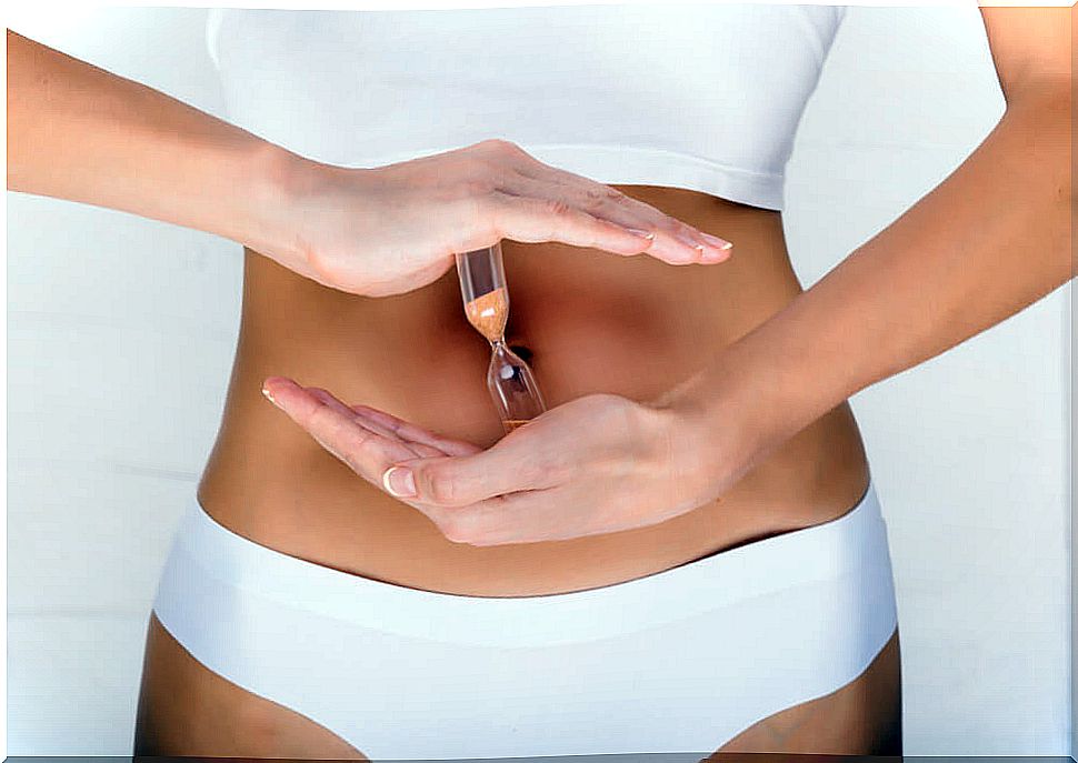 woman holding an hourglass on her belly indicating her fertile days