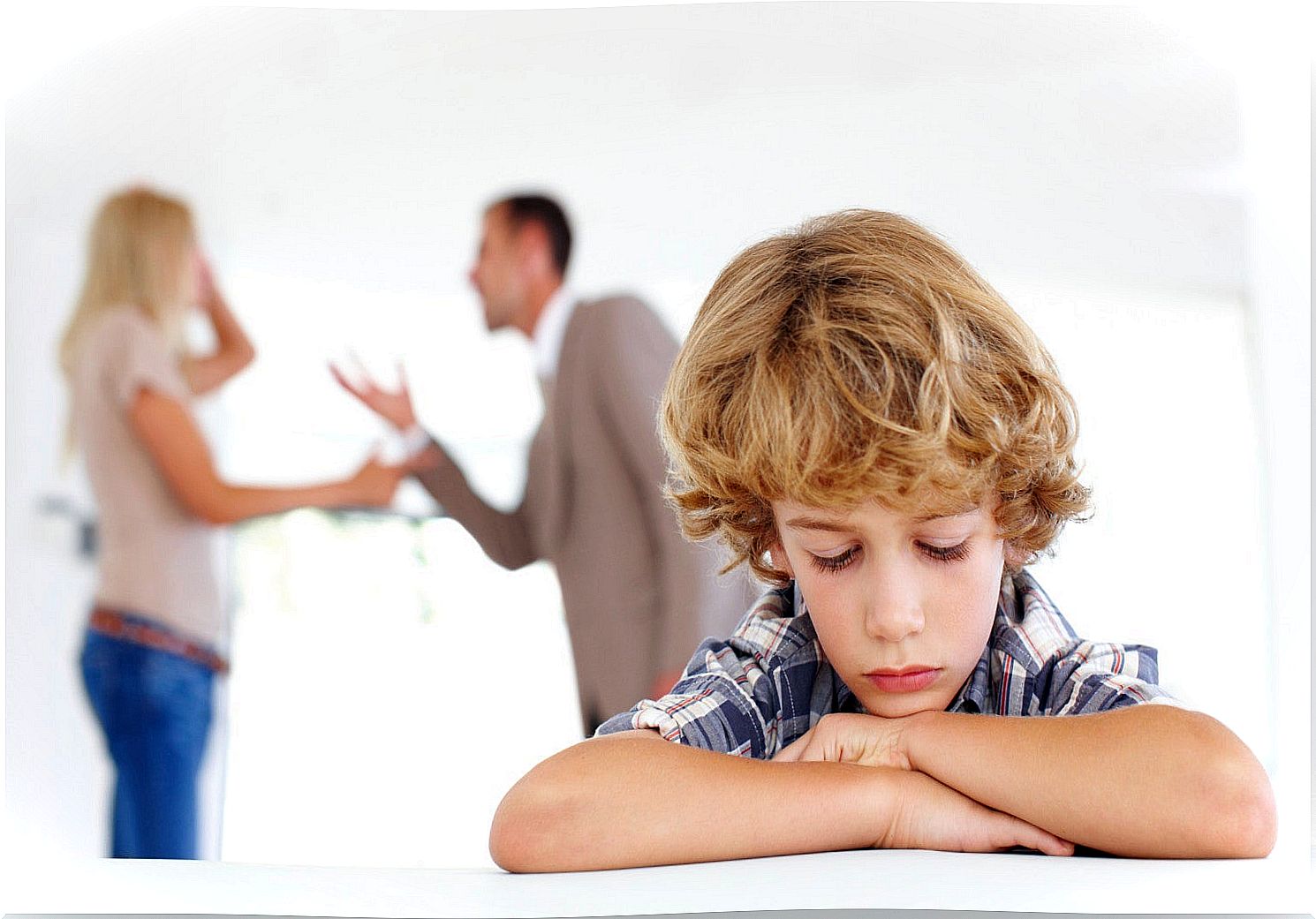 Sad child with parents arguing in the background.