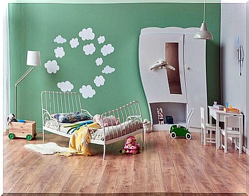 Room with a children's mural on the wall with clouds forming a circle 