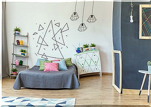 Room with a children's mural on the wall made of triangles of different sizes and in different orientations