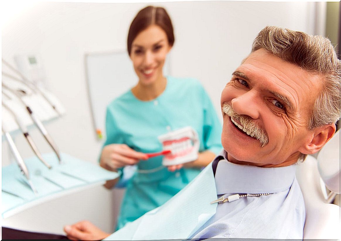 Older man in consultation with dentist for complications of dental implants.