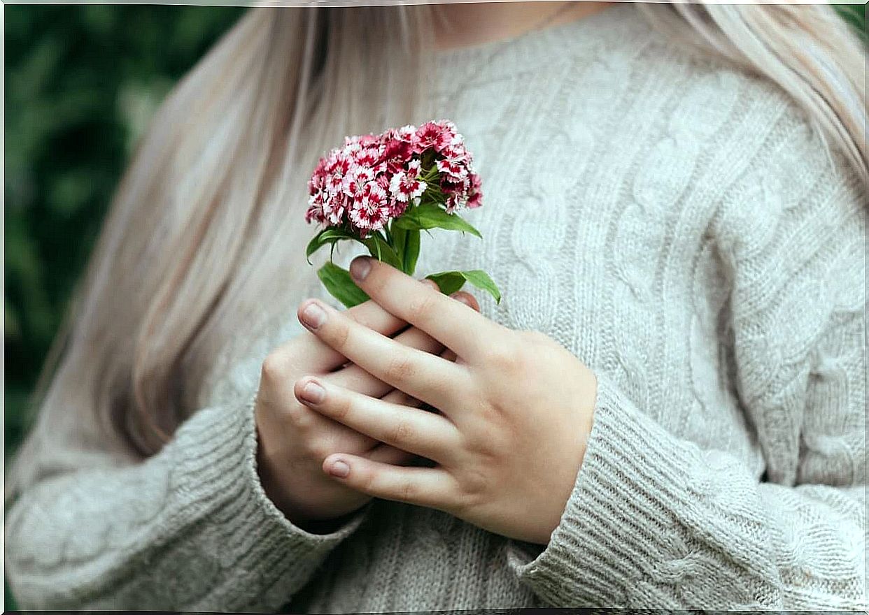 Woman holding a bunch of flowers.